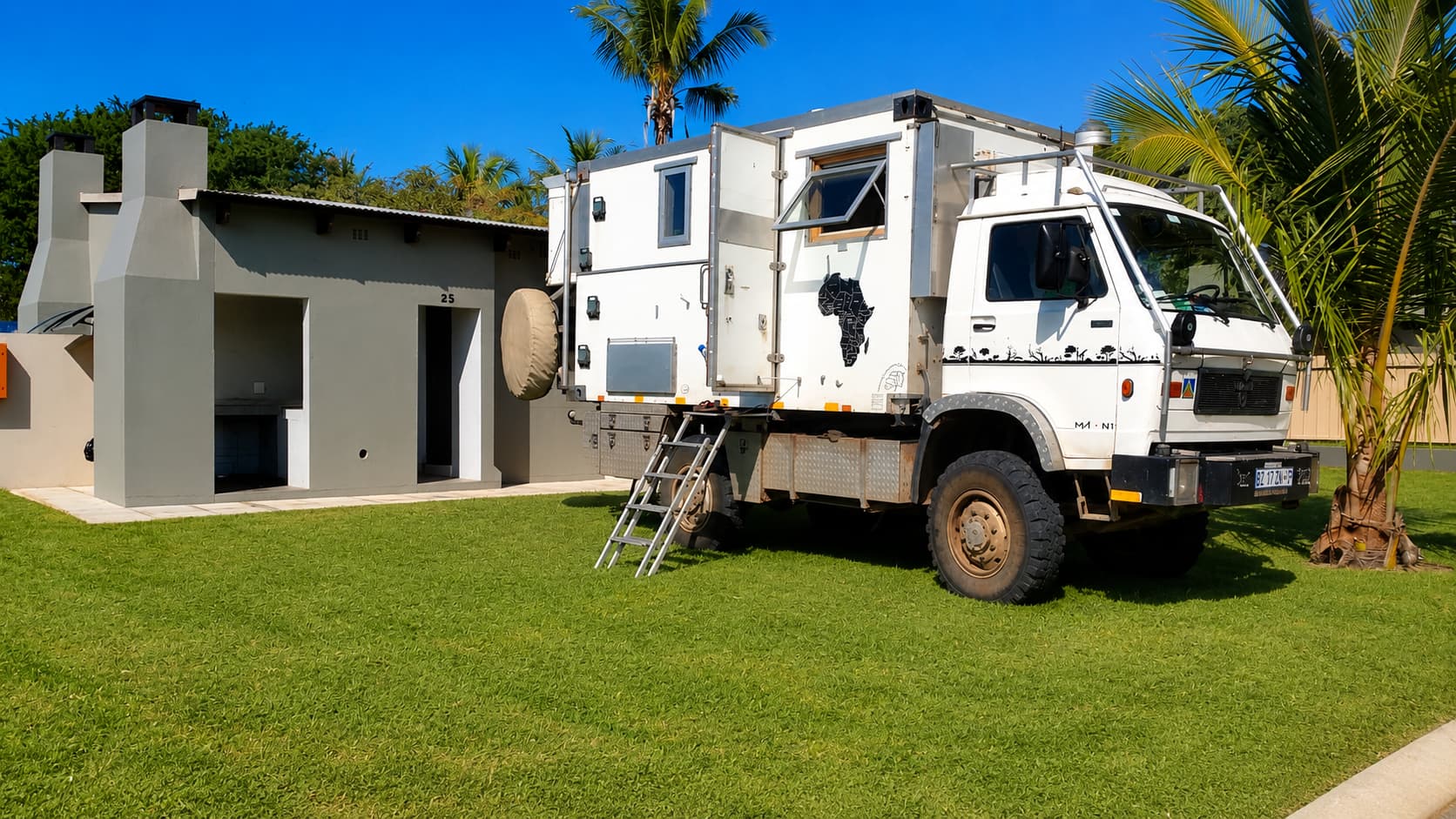 Overland camper truck parked on a grassed Beachfront stand