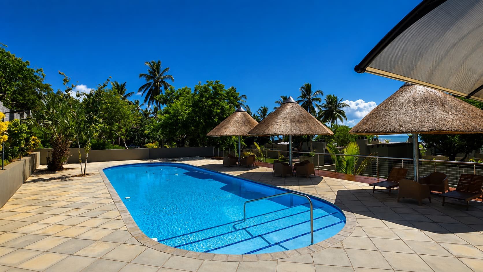 Swimming pool with thatched umbrellas near the Premium stands