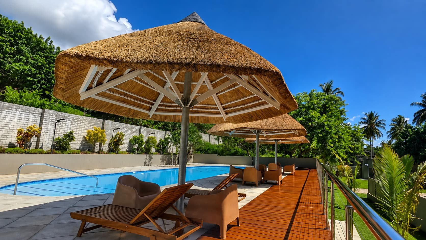 Thatched umbrella and loungers on the pool deck