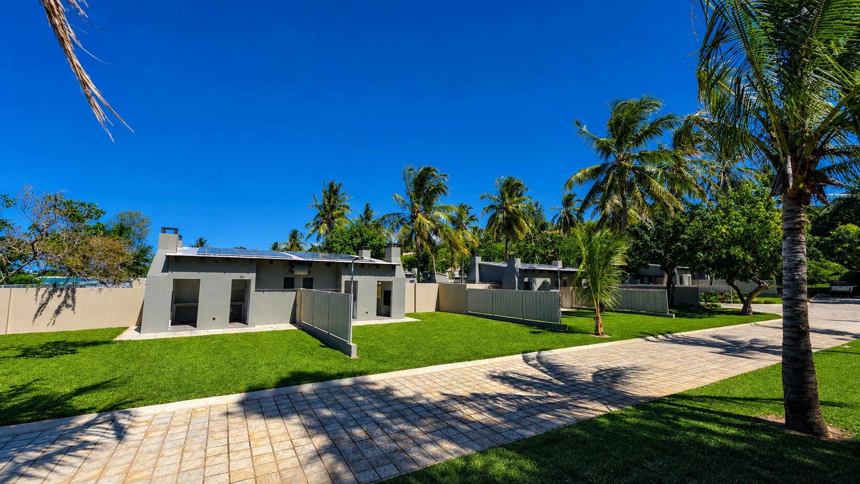 Premium stand exterior with solar panels and a palm-lined garden