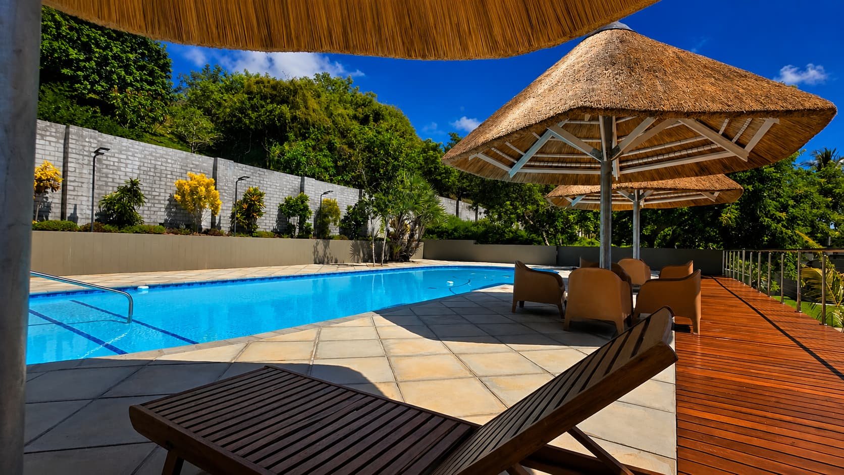 Thatched umbrella and loungers beside the pool
